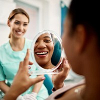 Patient smiling at reflection in treatment chair