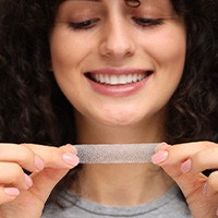 Woman holding a whitening strip