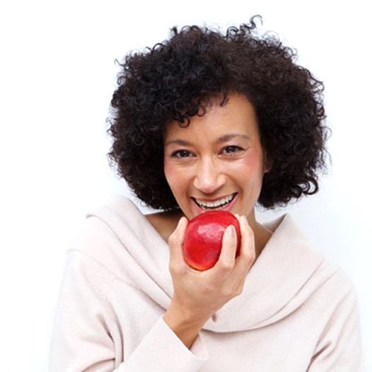 woman biting into a red apple