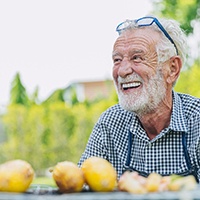 Woman with blond hair and dentures smiling