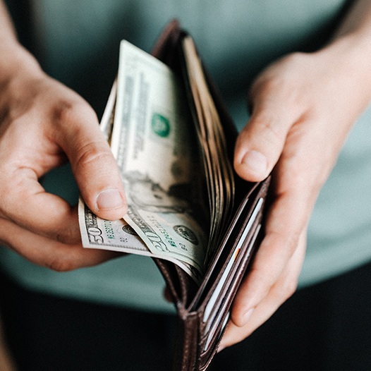 Man holding open wallet with cash