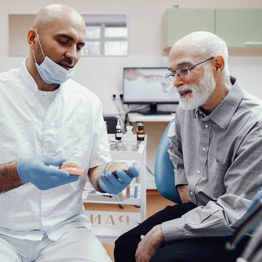 A dentist talking to his patient about implant dentures