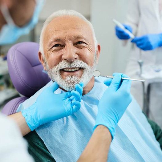 An older man happy with his new implant dentures