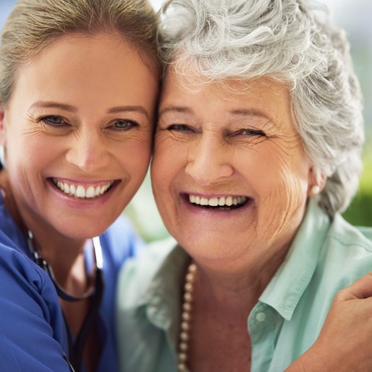 Mother and daughter smiling after dental implant tooth replacement