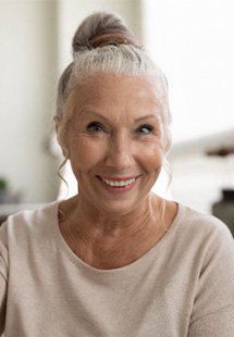 older woman smiling while giving thumbs up 