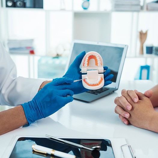 Dentist and patient sitting at desk during consultation