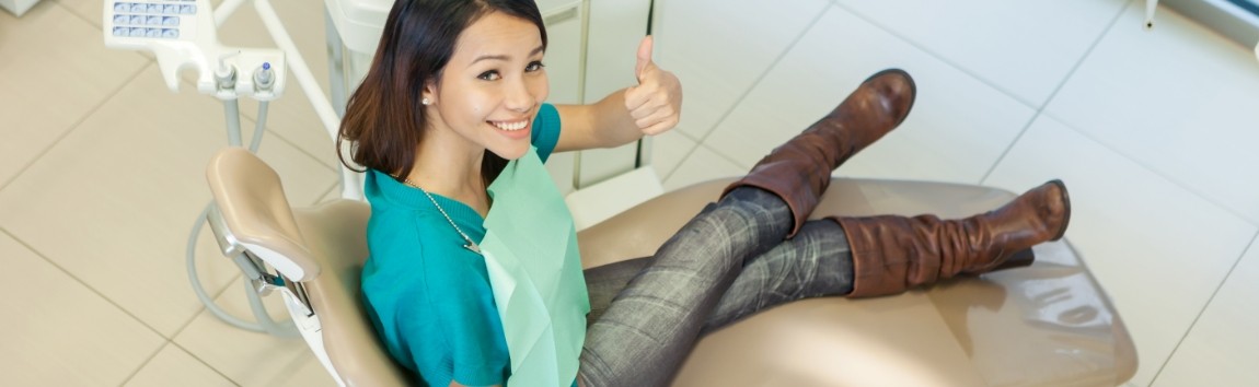 Woman giving thumbs up during preventive dentistry visit