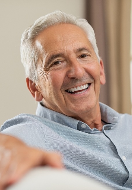 Man smiling after visiting his dentist in Pensacola Florida