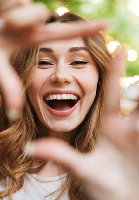 young woman smiling after teeth whitening in Pensacola