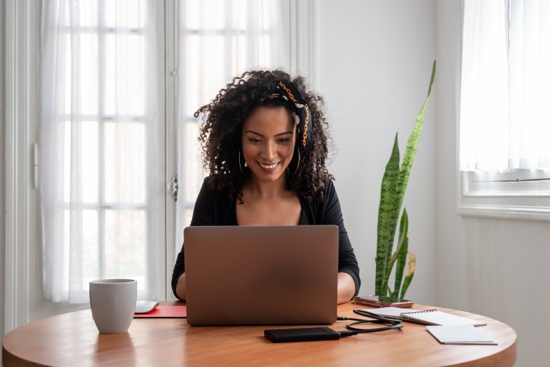 Woman with dental implants working on the computer