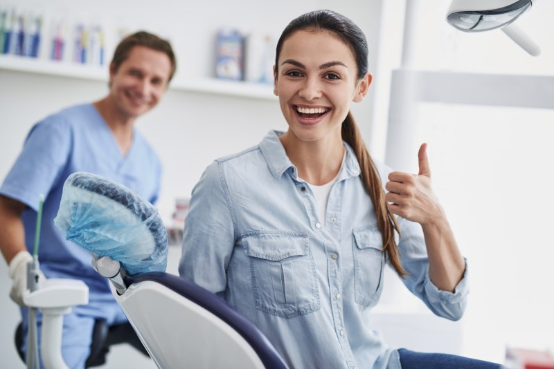 A lovely young lady doing a thumbs up at a dentist’s office