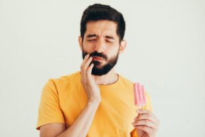 Man having tooth sensitivity after eating frozen treat