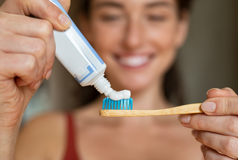 Woman putting toothpaste on toothbrush